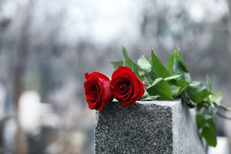 due rose rosse su lapide in pietra