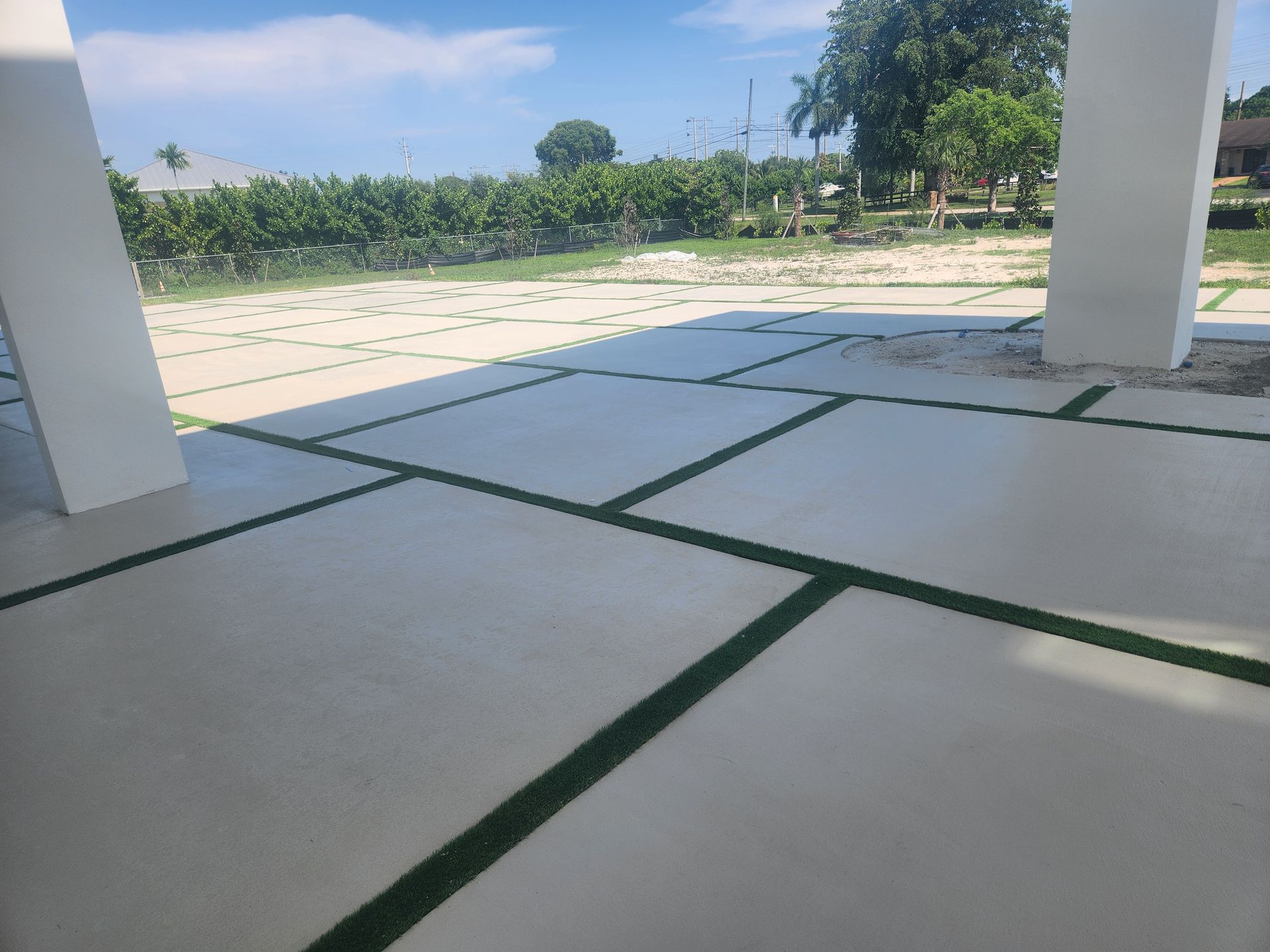 A patio with a lot of tiles and grass on it.