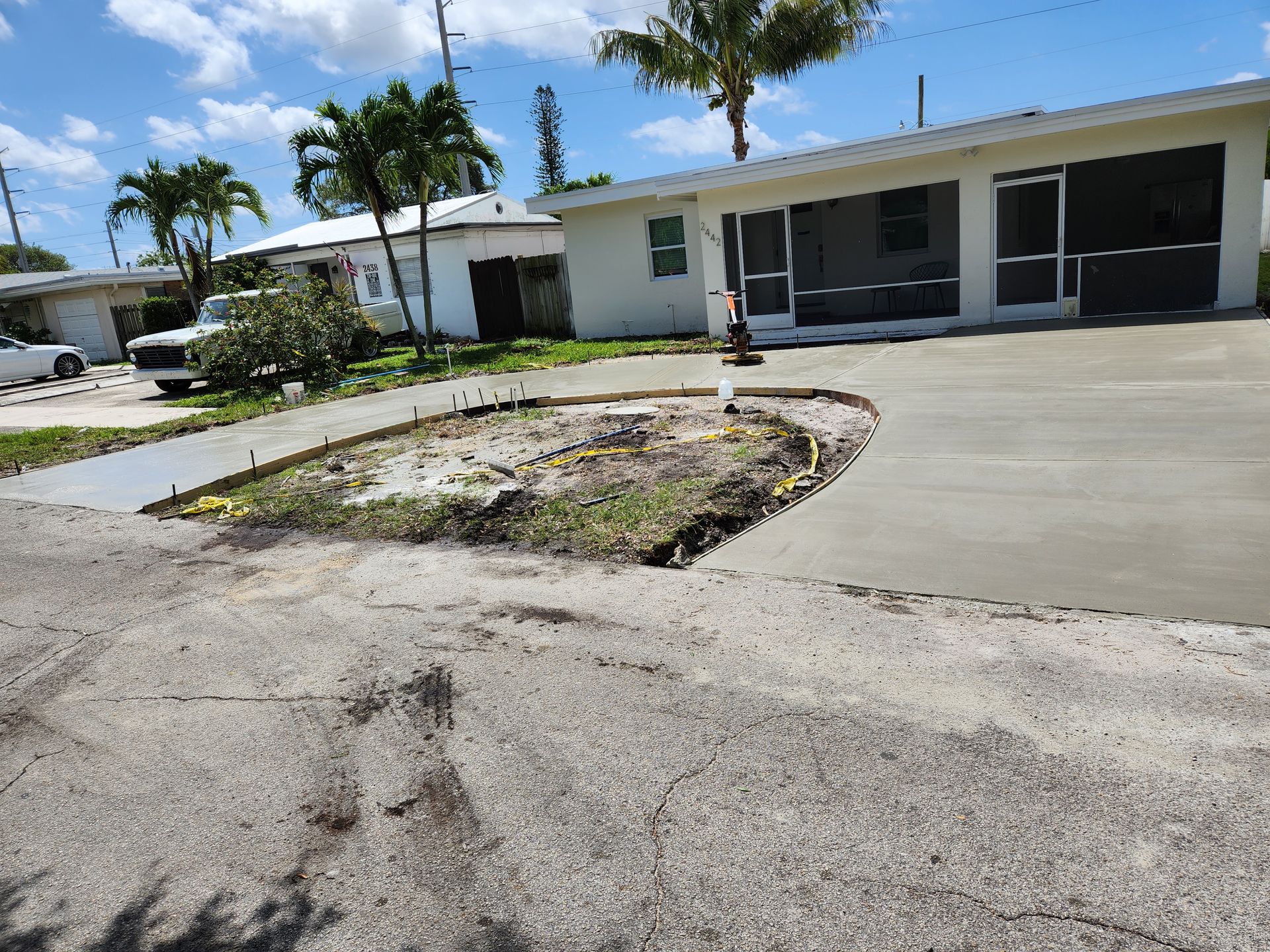 A concrete driveway is being built in front of a house.