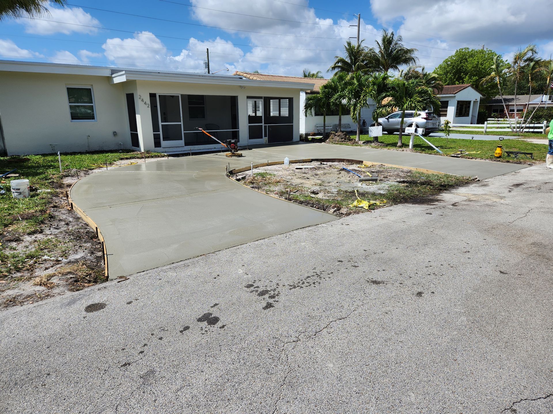 A concrete driveway is being built in front of a house.