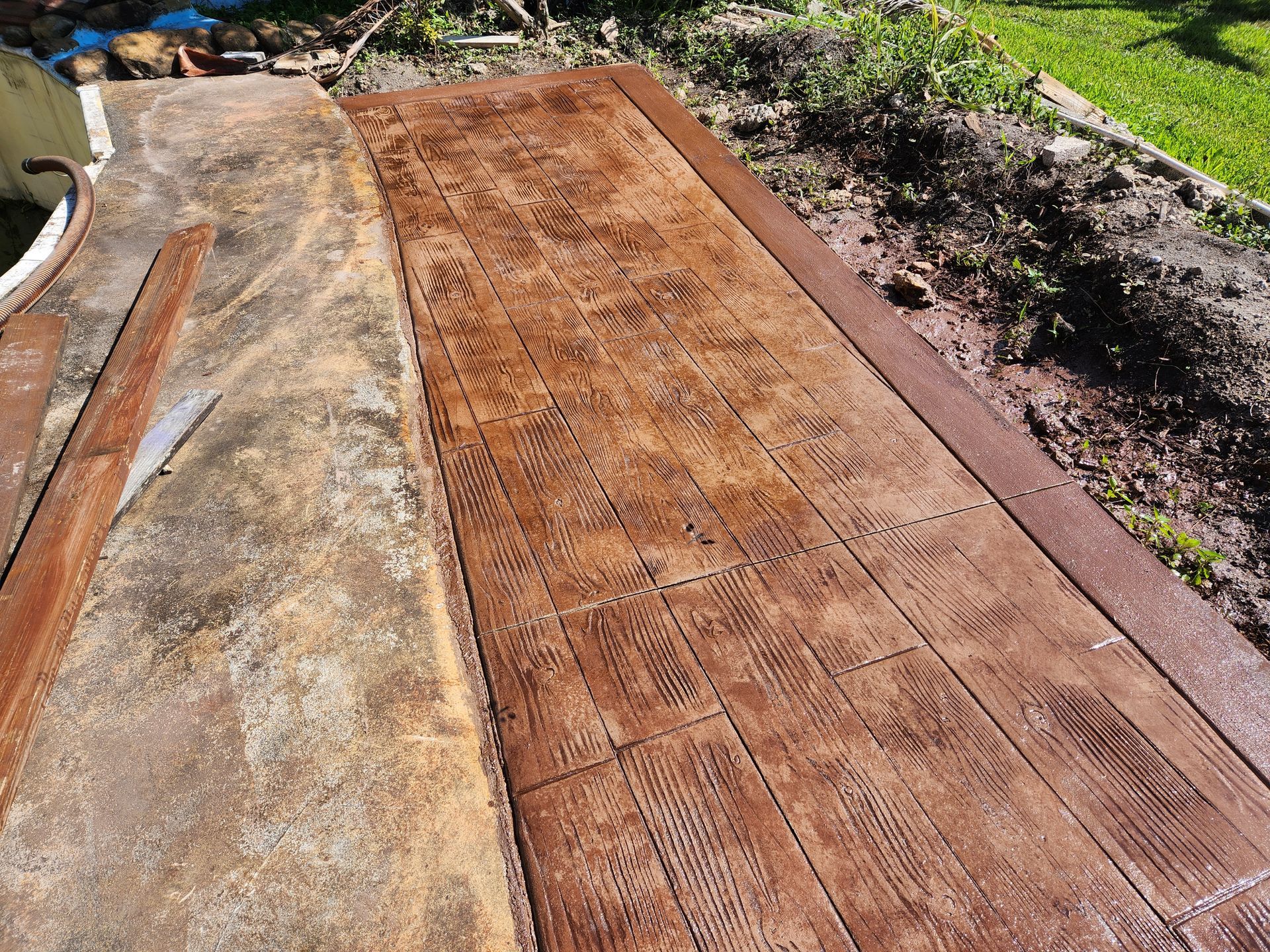 A concrete walkway with a wooden pattern on it.