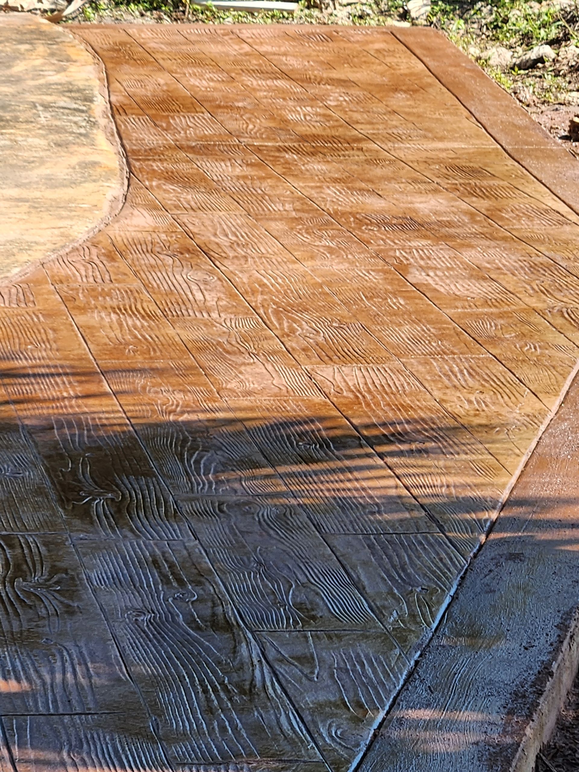 A close up of a concrete patio with a wood grain pattern.