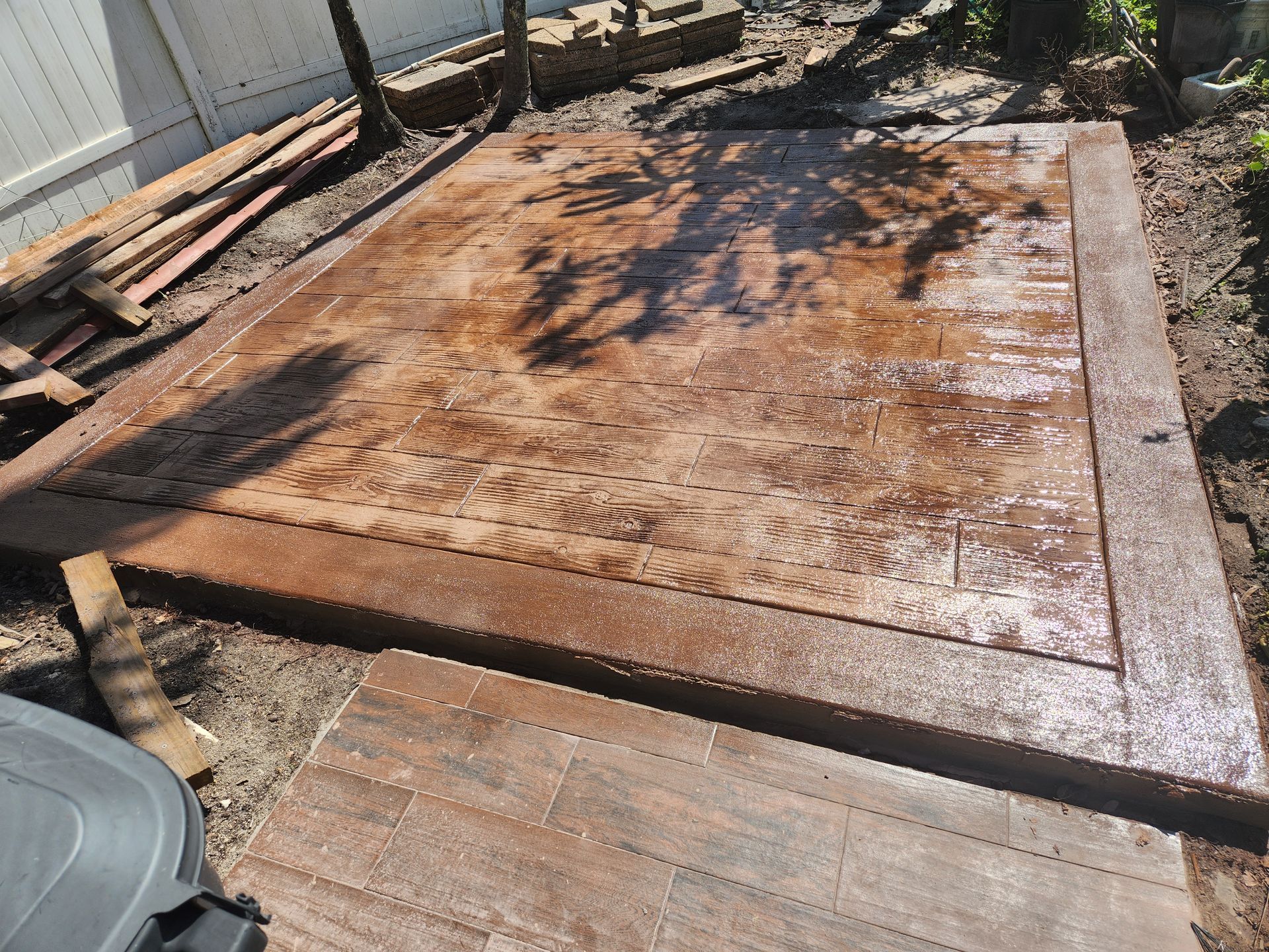 A concrete floor with a fence in the background