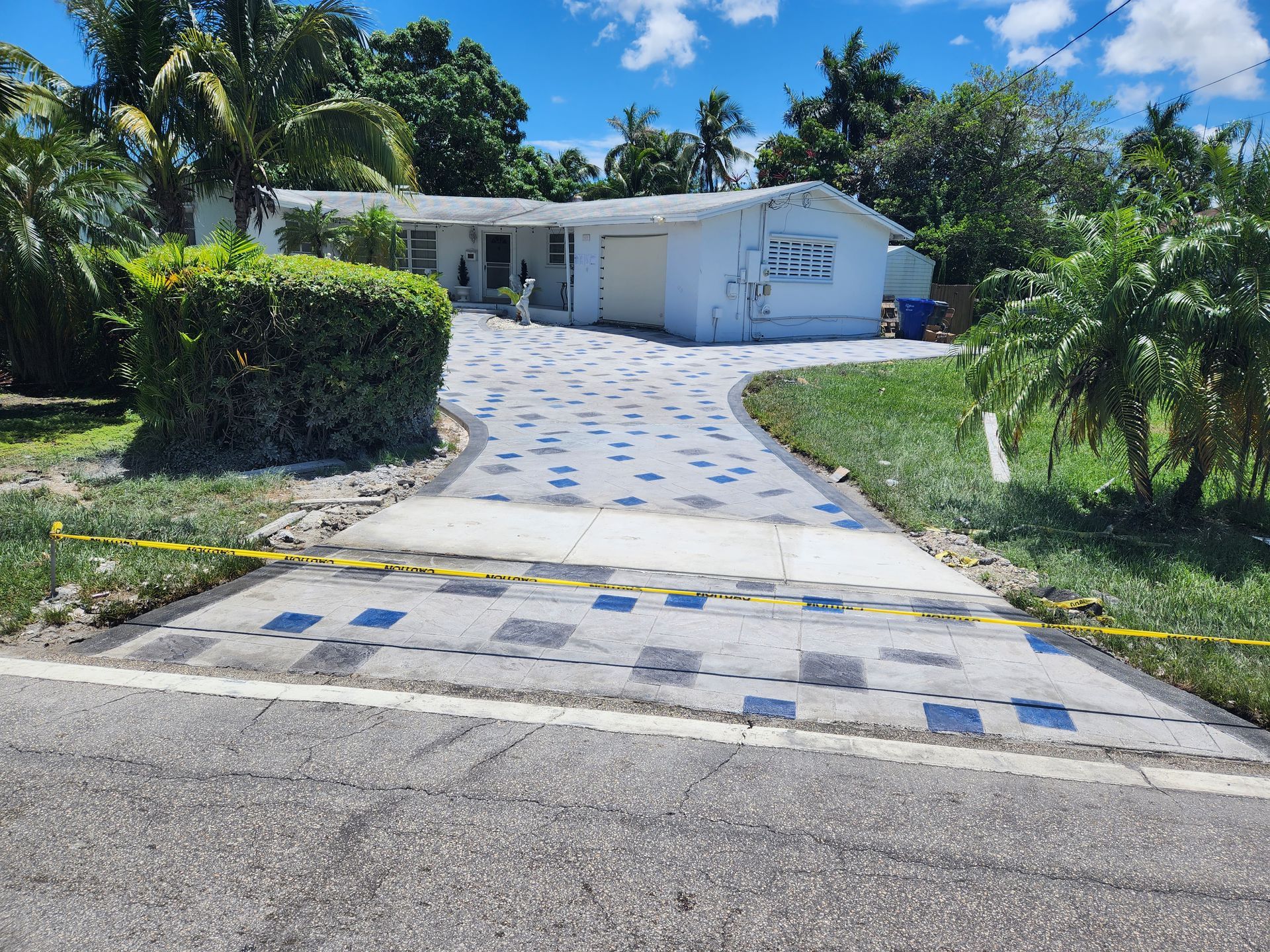 A white house with a concrete driveway leading to it.