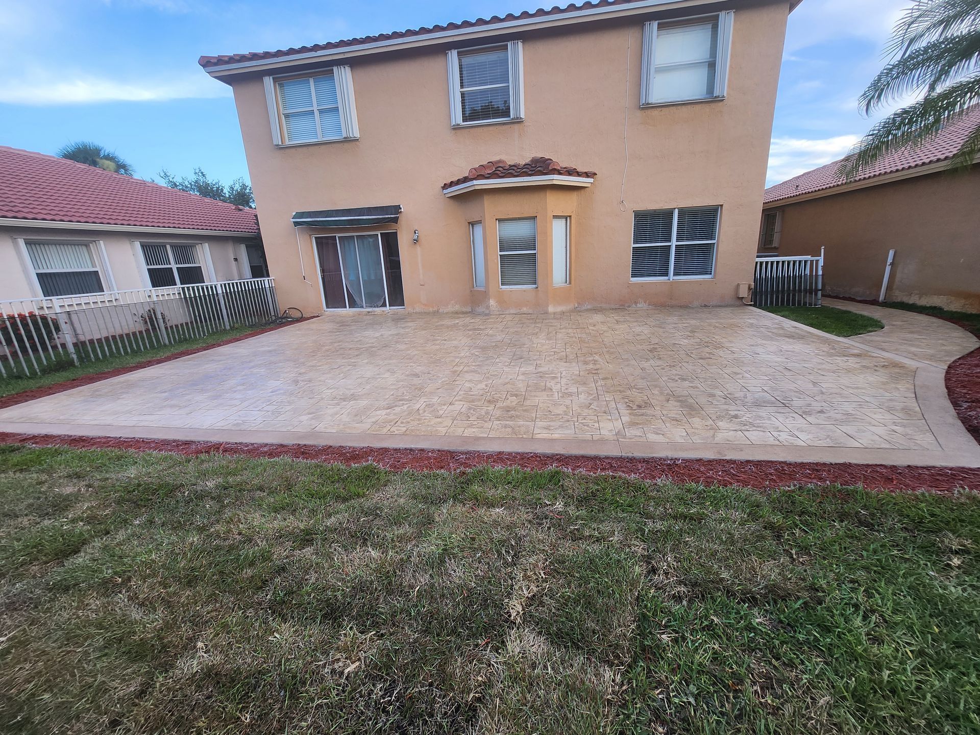 A large house with a concrete driveway in front of it.