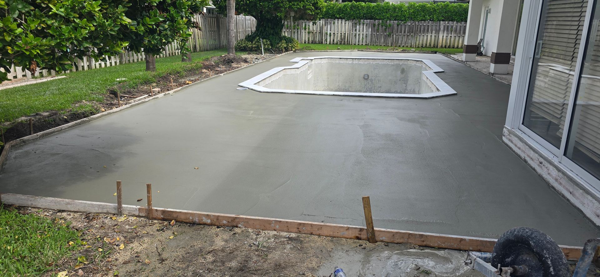 A Concrete Patio Is Being Built Next to A Swimming Pool.