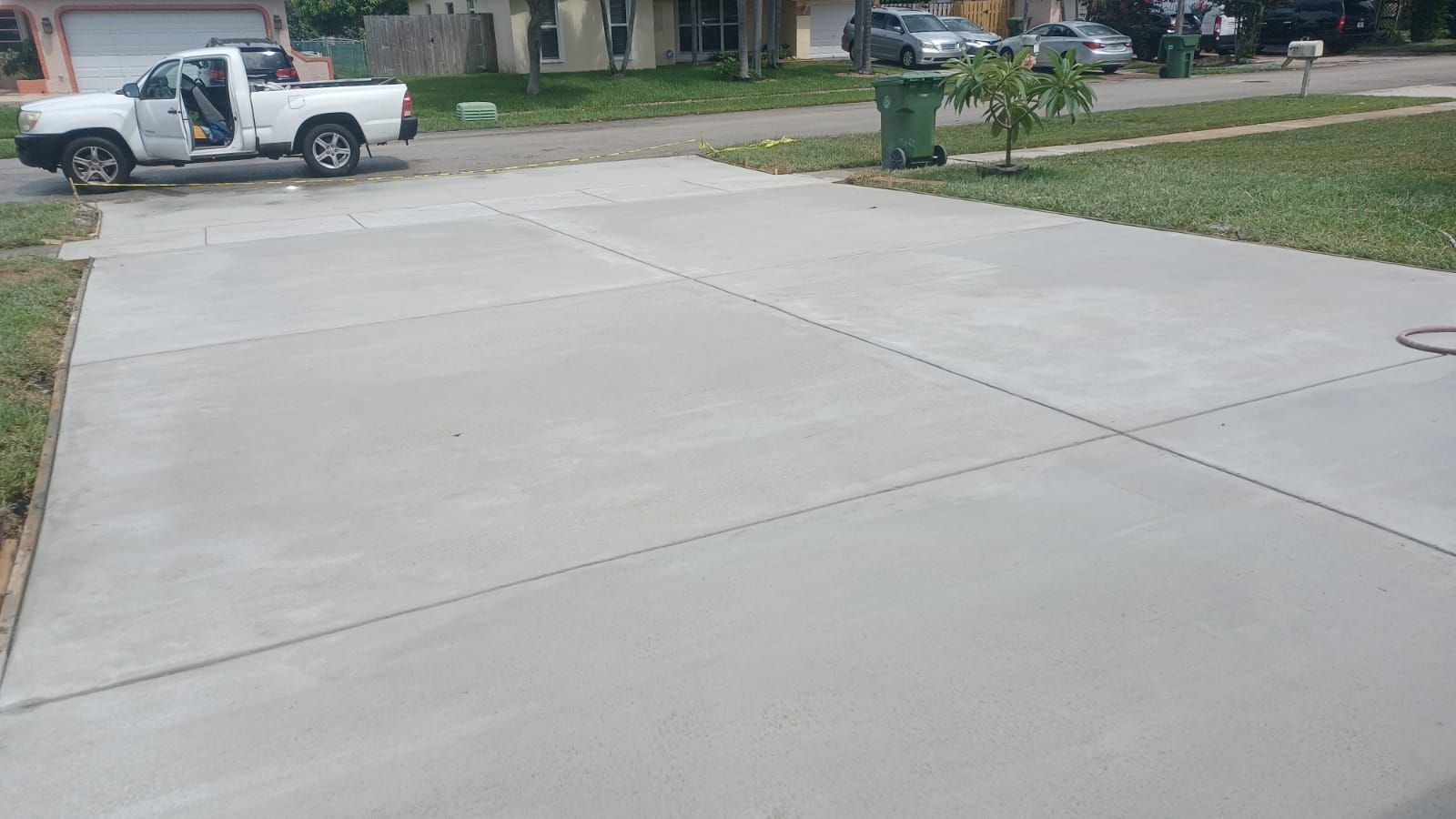 A white truck is parked in a concrete driveway.