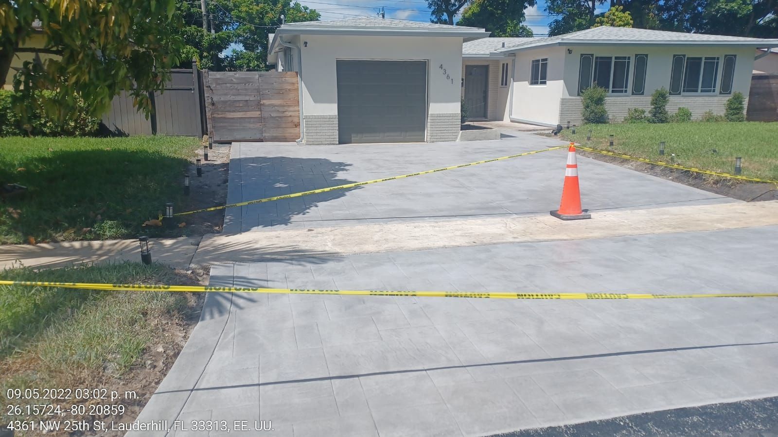 A concrete driveway is being built in front of a house.