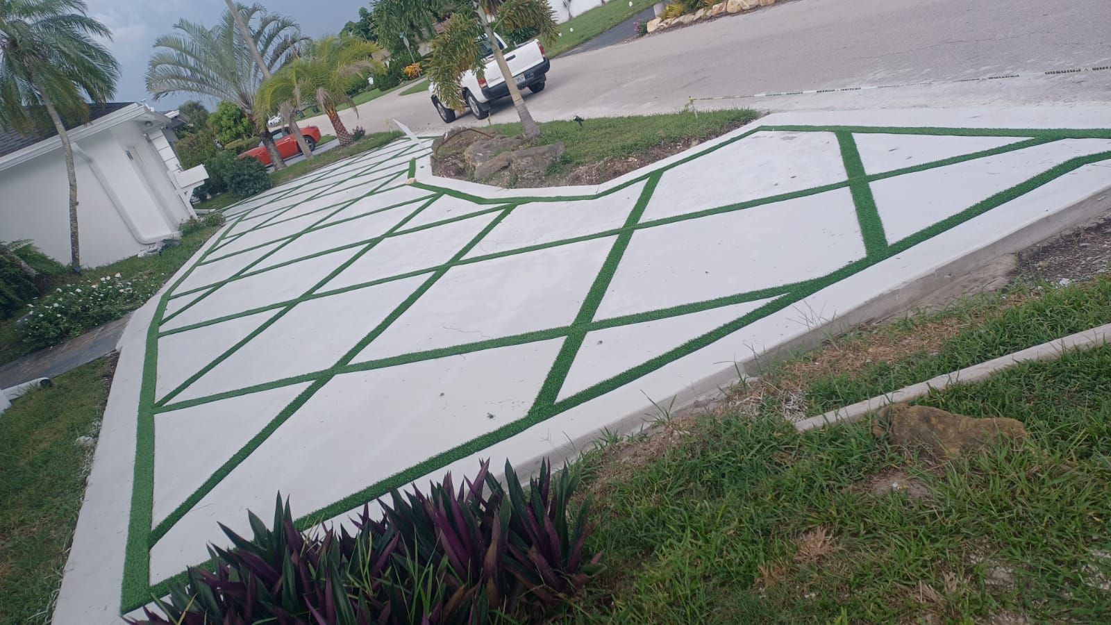 A concrete driveway with a geometric design painted on it.