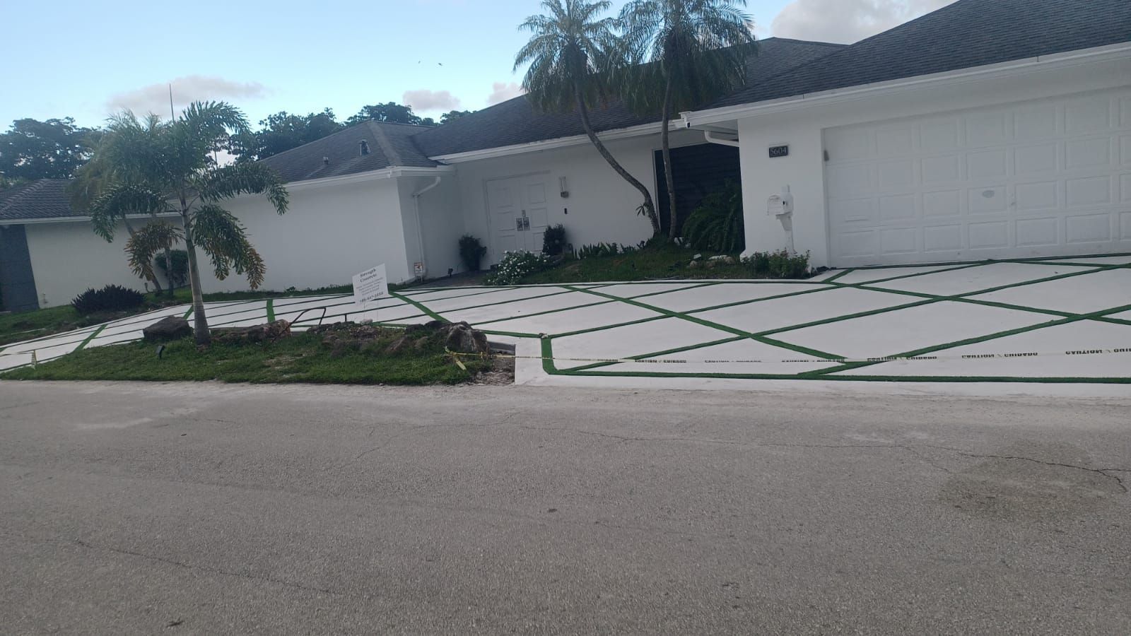 A white house with a large driveway in front of it.