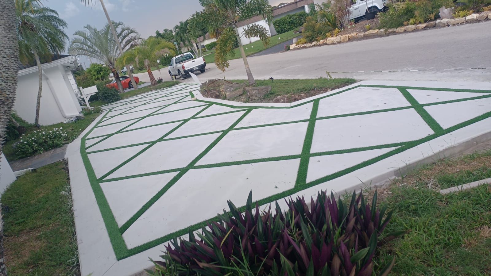 A concrete driveway with a diamond pattern painted on it.