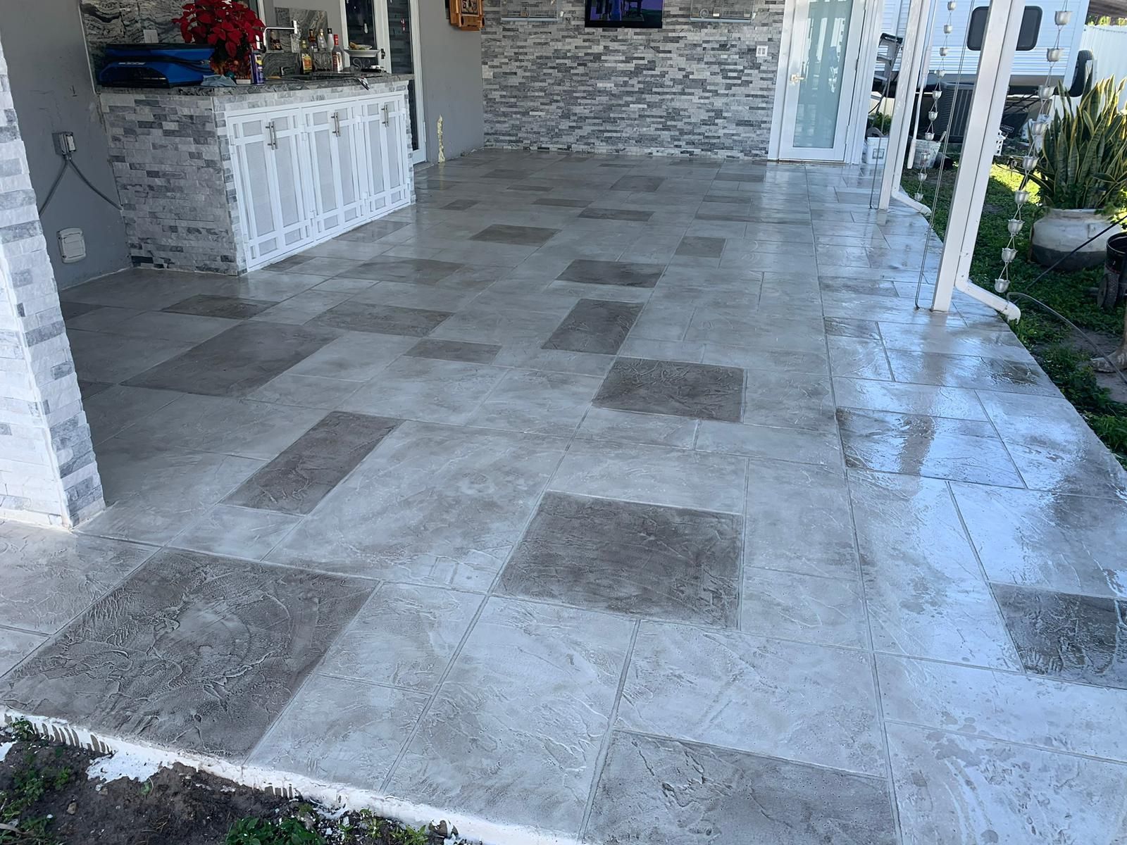 A patio with a tiled floor and a brick wall.