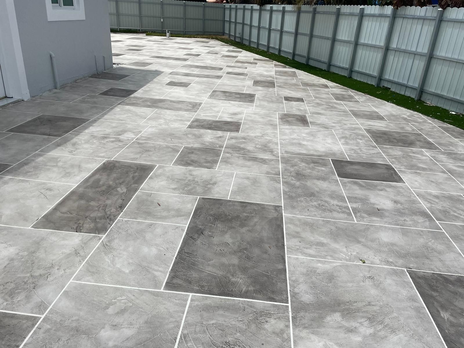 A patio with a lot of tiles on it and a fence in the background.