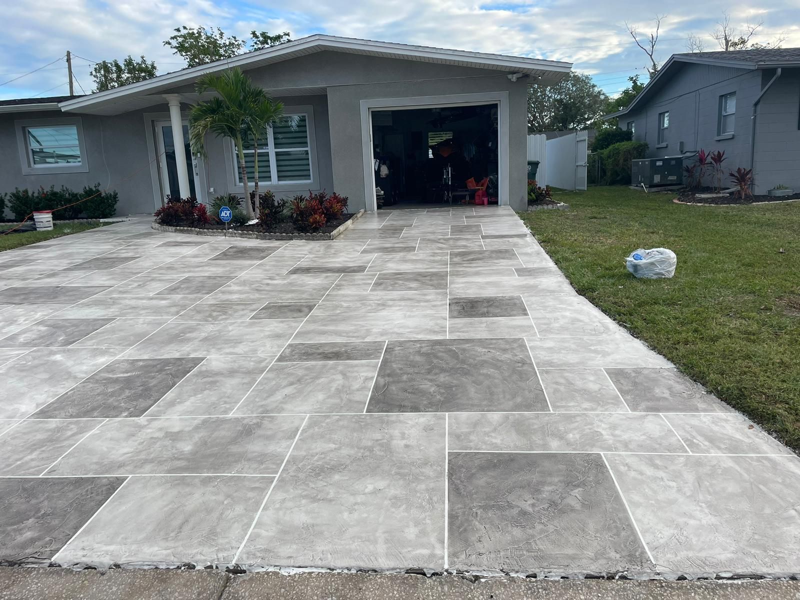 A concrete driveway leading to a house with a garage.