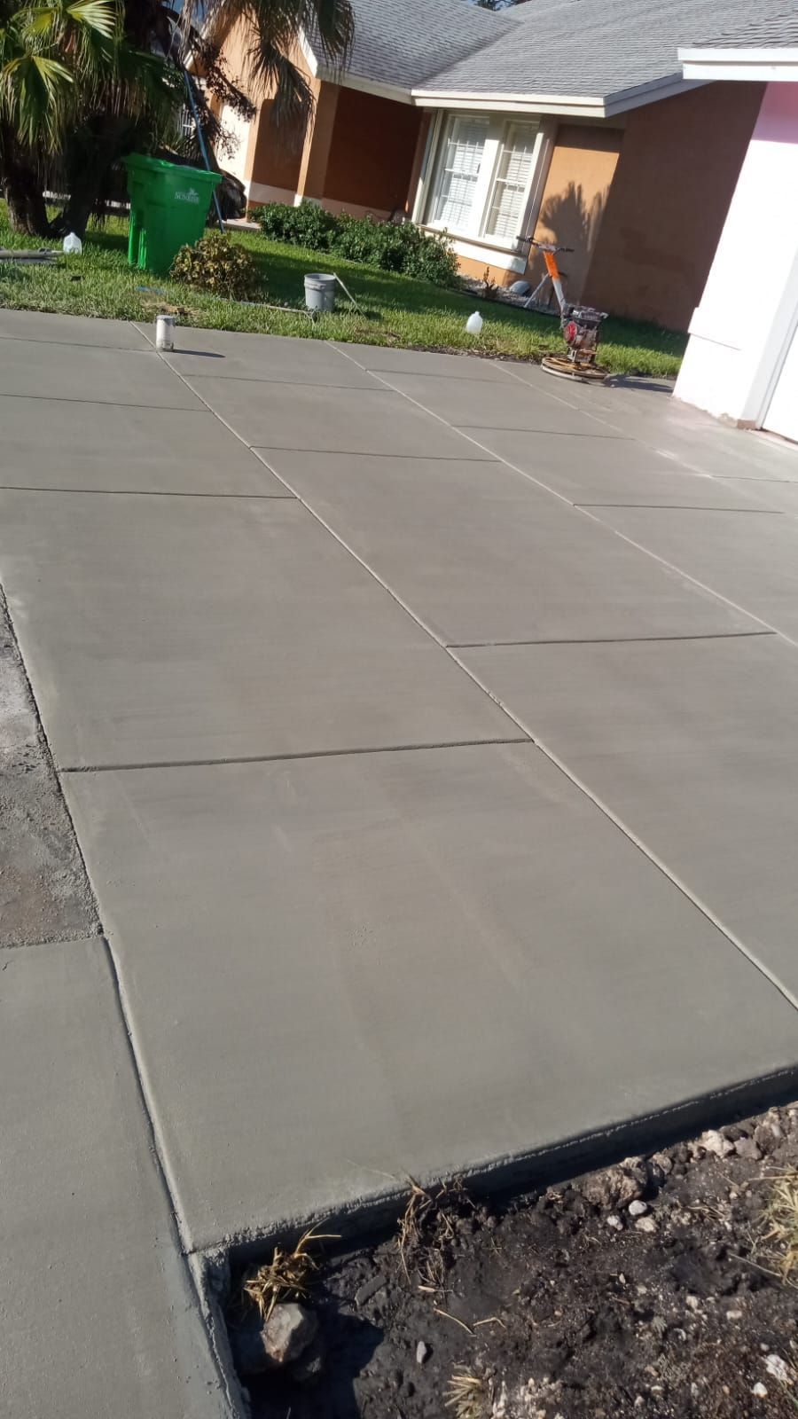 A concrete driveway is being built in front of a house.