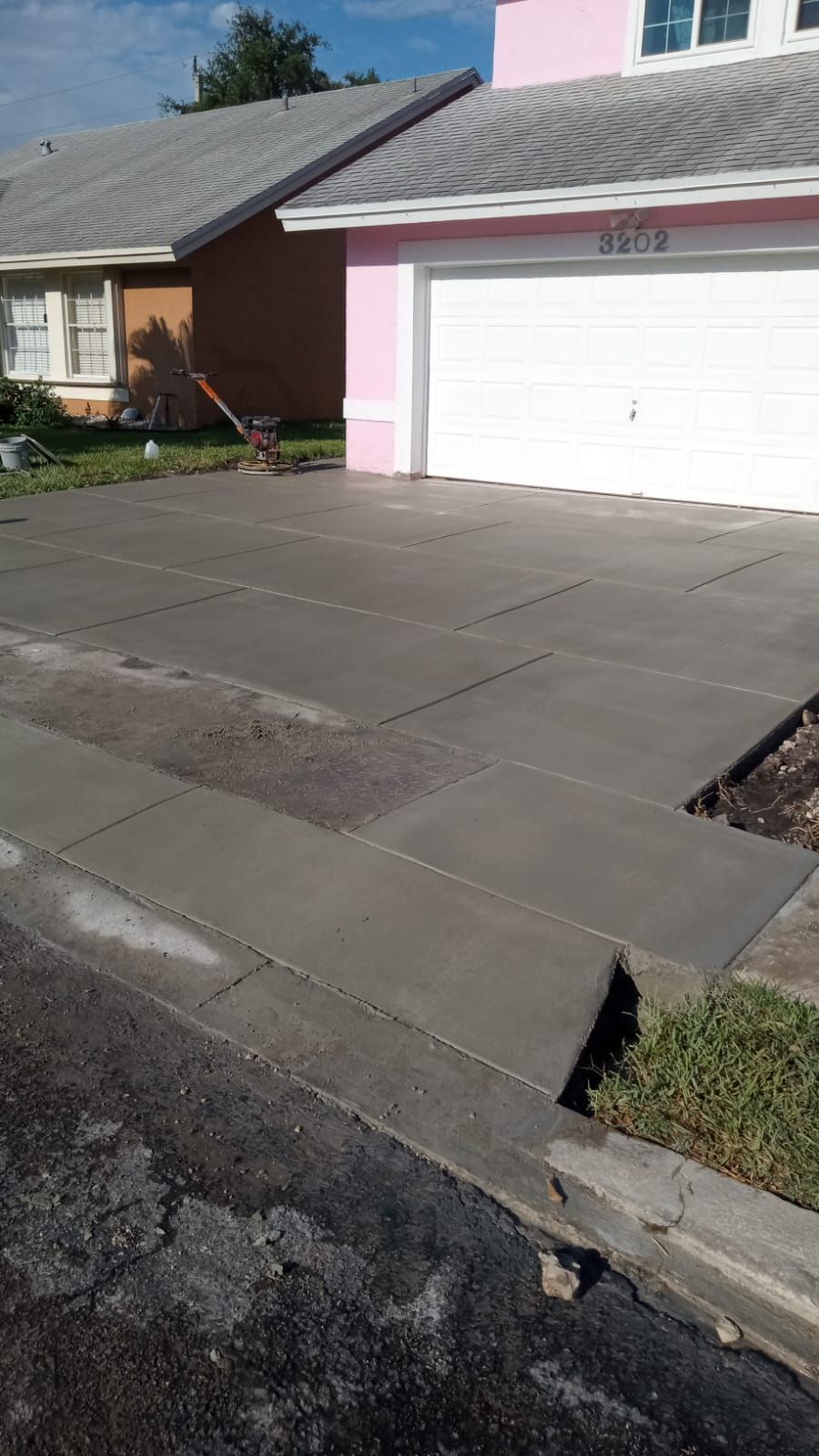 A concrete driveway is being built in front of a house.