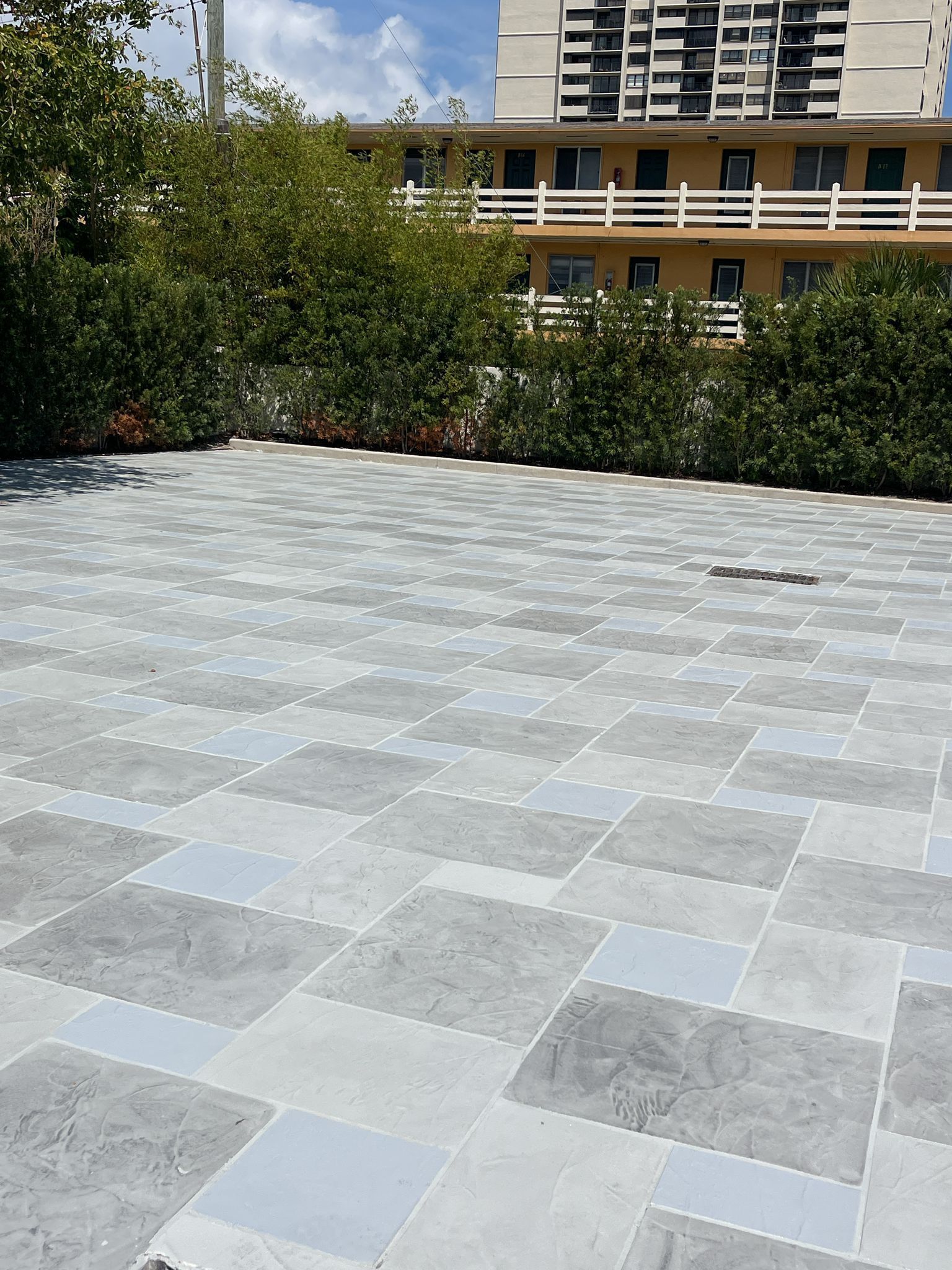 A Parking Lot with A Building in The Background and A Tiled Floor.