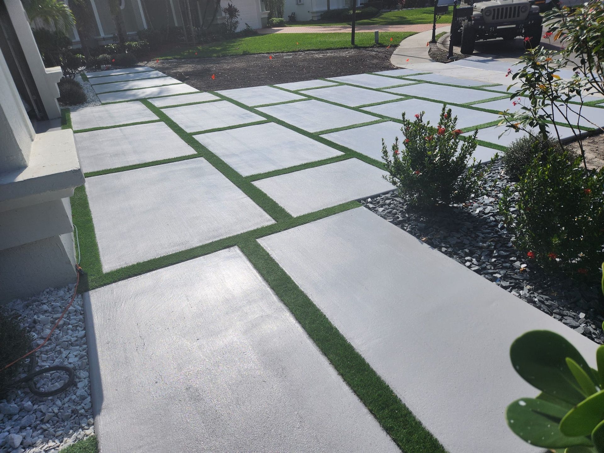 A concrete walkway with grass on the side of it