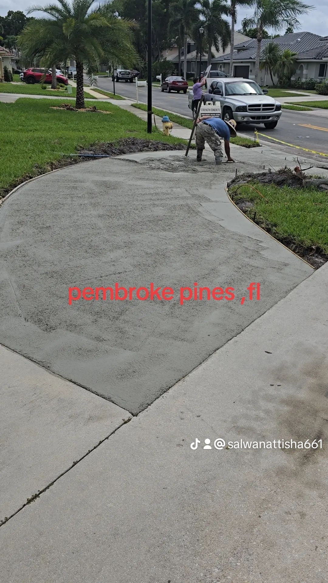 A Couple of Men Are Working on A Concrete Driveway.