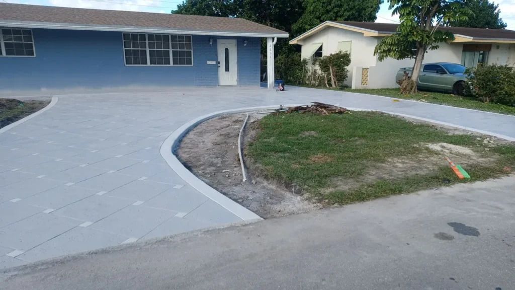 A concrete driveway is being built in front of a house.