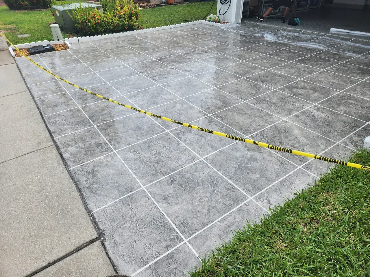 A concrete driveway with a yellow tape around it.