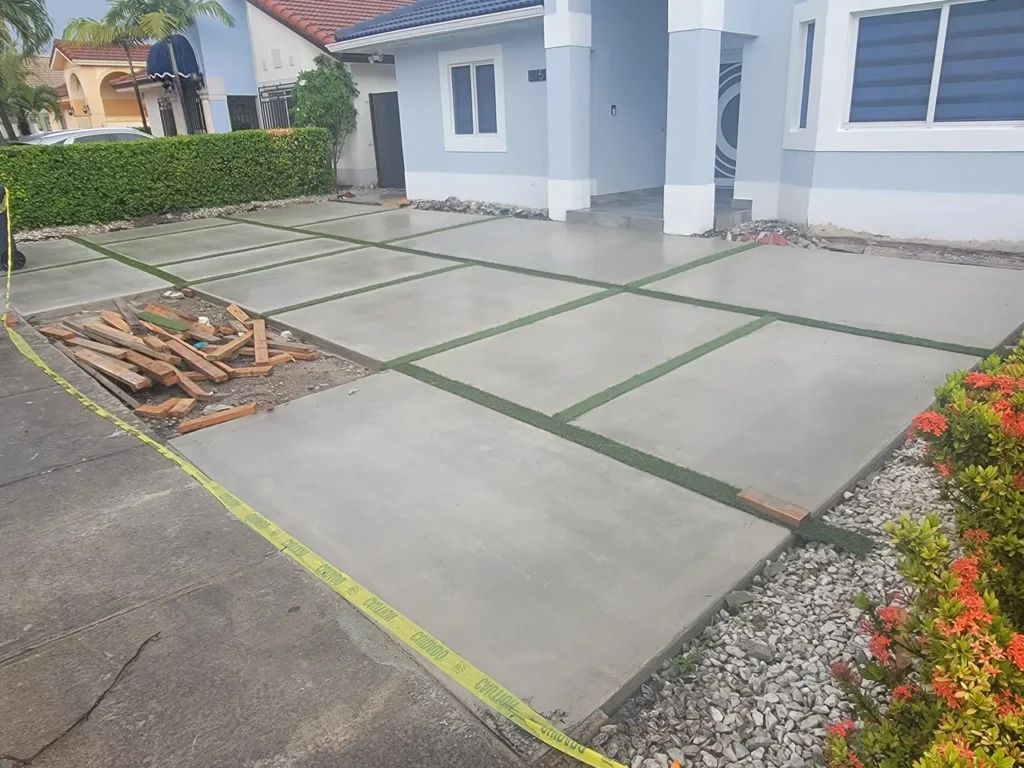 A concrete driveway is being built in front of a house.