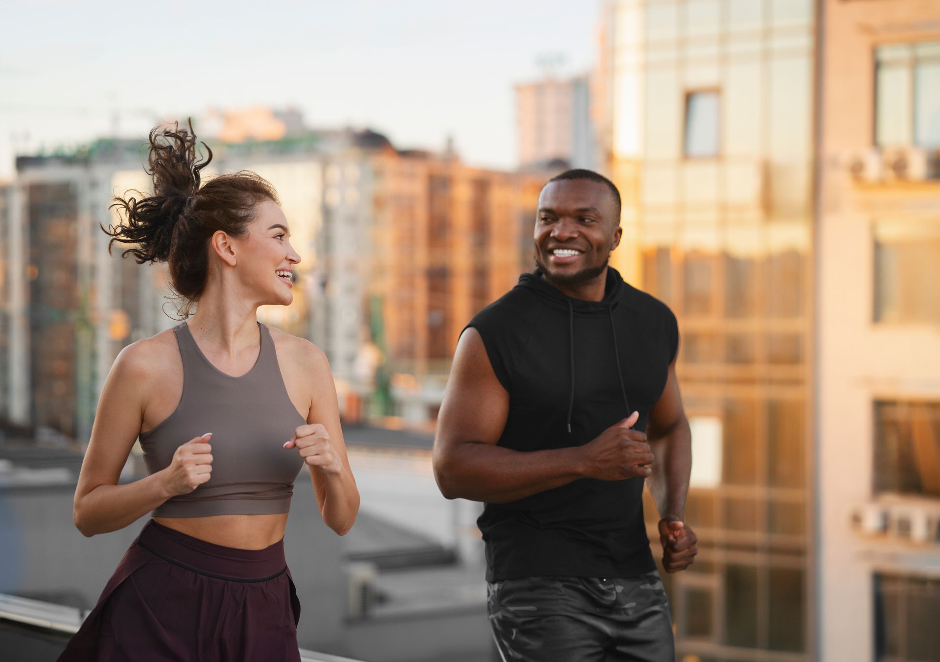 A man and a woman are running in the city.