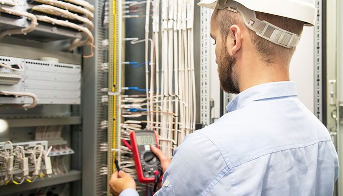 Two vending machines with illuminated frames, positioned against a concrete wall, at night. Crosswalk in foreground.