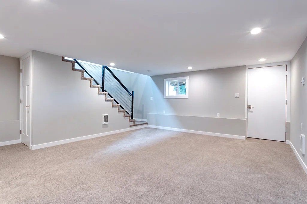 Freshly renovated basement with new carpet floors and a pristine paint job.