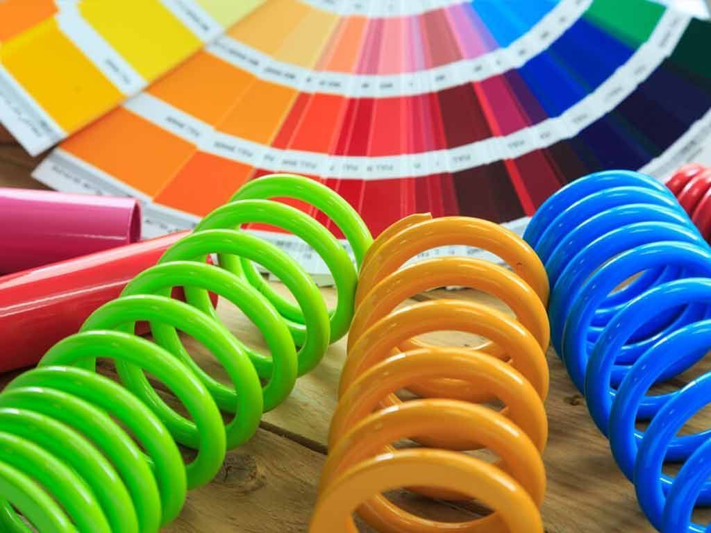 A Bunch of Colourful Springs Are Sitting on a Wooden Table — Hastings Valley Powdercoaters in Harrington, NSW