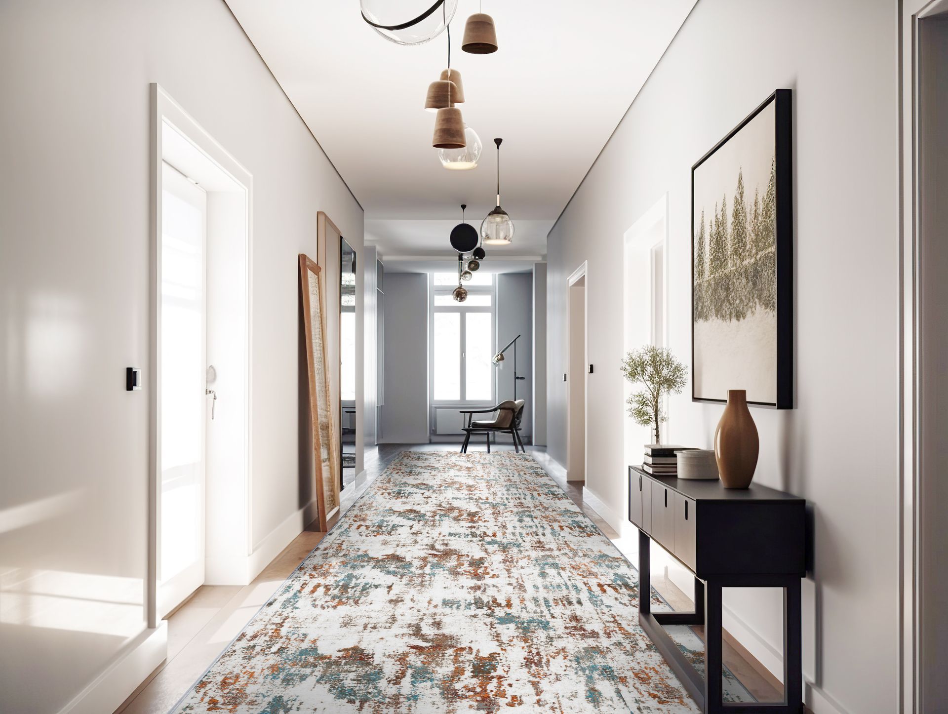 Long hallway with white walls, patterned rug, artwork, and decorative lighting.