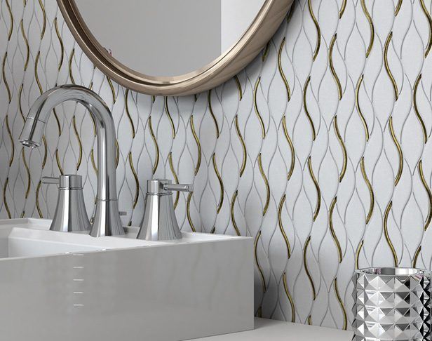 Bathroom sink with white and gold wave-patterned tile, chrome faucet, and gold-framed mirror.