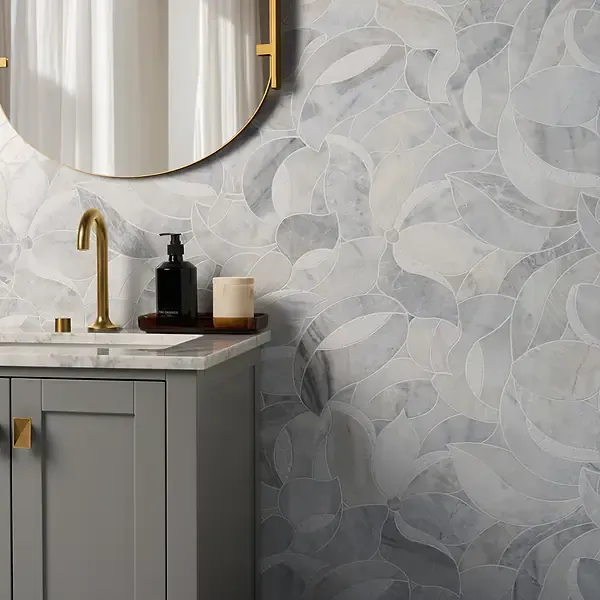 Bathroom with gray cabinet, gold fixtures, and floral patterned marble wall tile.