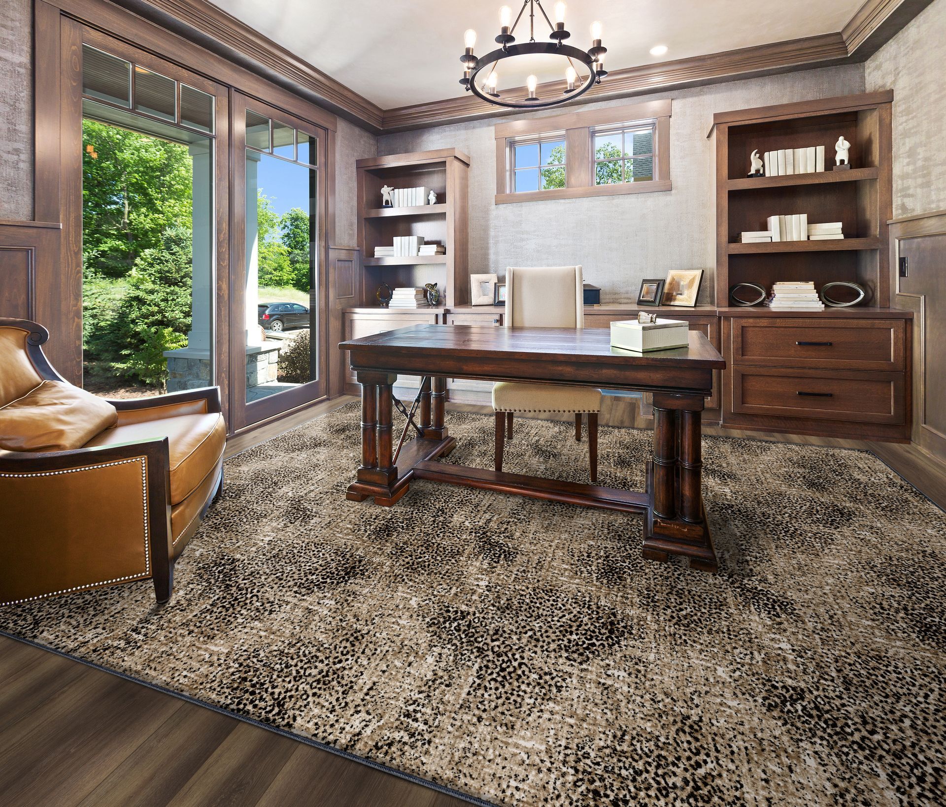 Home office with a desk, bookshelves, a rug, and a leather chair next to a doorway to a green outdoor space.