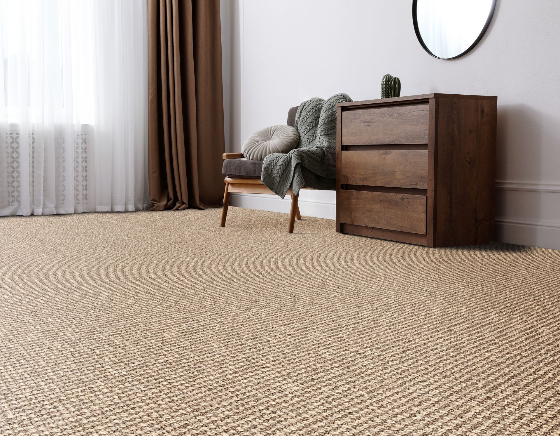 Tan woven rug in a room with a wooden dresser, chair, and curtains.