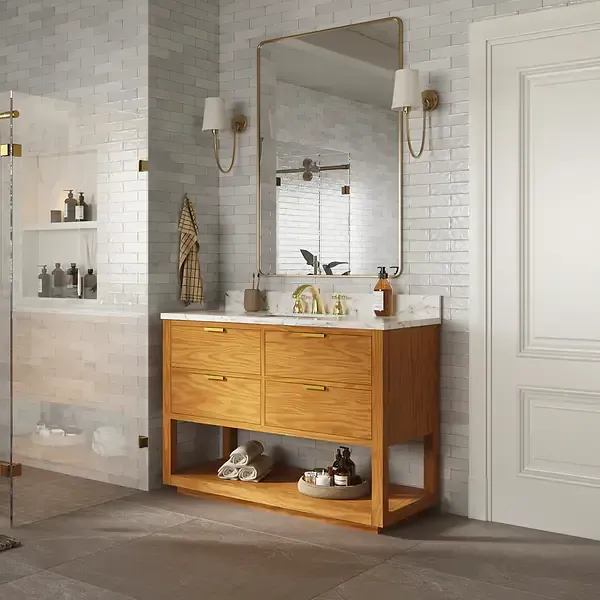 Bathroom with a wooden vanity, marble countertop, and rectangular mirror. Includes a glass shower and white brick wall.