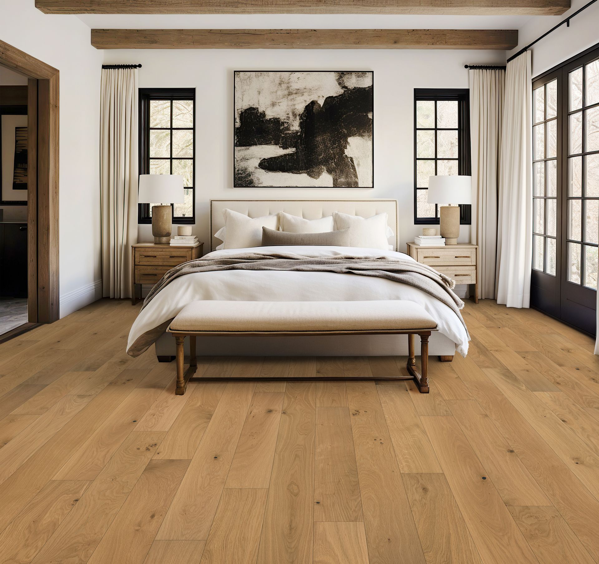 Bedroom with hardwood floor, bed, bench, artwork, windows, and neutral colors.