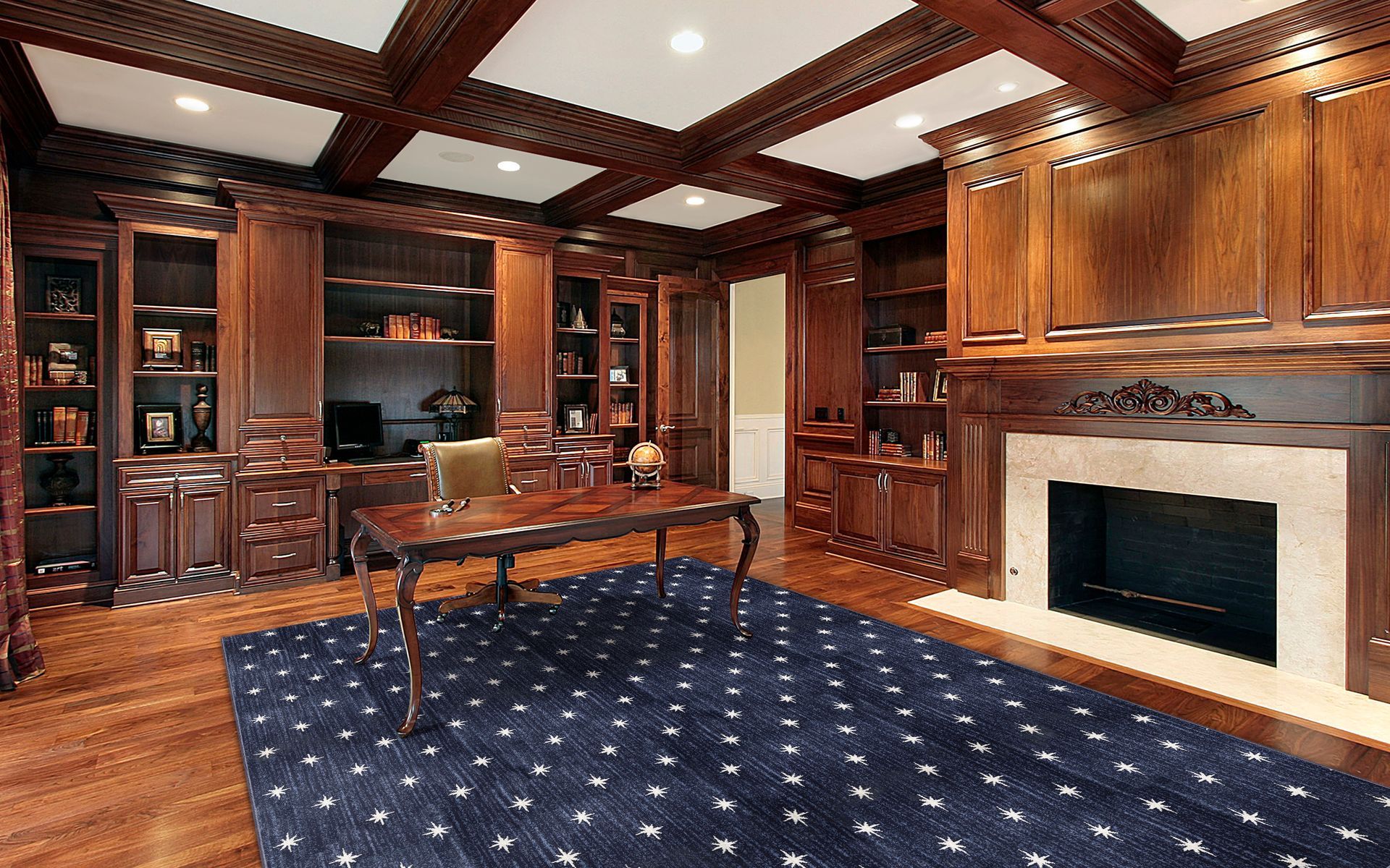 Elegant wood-paneled office with built-in bookshelves, fireplace, desk, and a blue patterned rug.