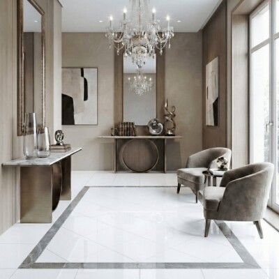 Elegant entryway with white tiled floor, chairs, and chandelier.