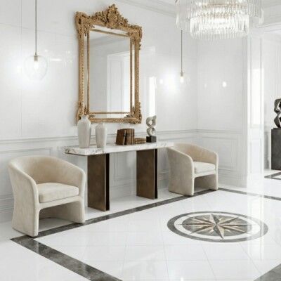 Elegant white foyer with marble accents, gold mirror, and velvet chairs.