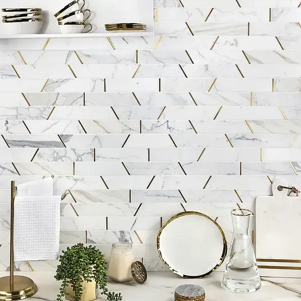 White marble backsplash with gold accents in a kitchen, including shelf with cups and a counter with decor.