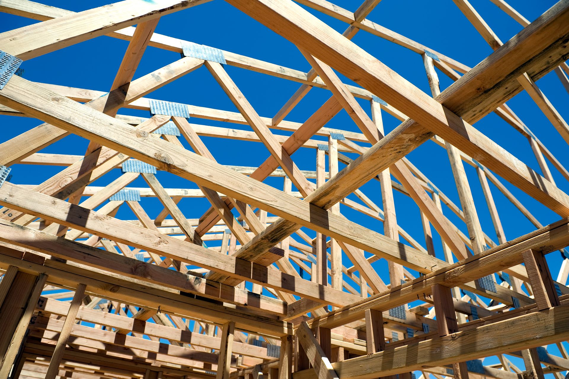 Looking up through new house frame with quality truss suppliers visible.