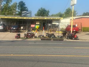 A red truck is parked in front of a store
