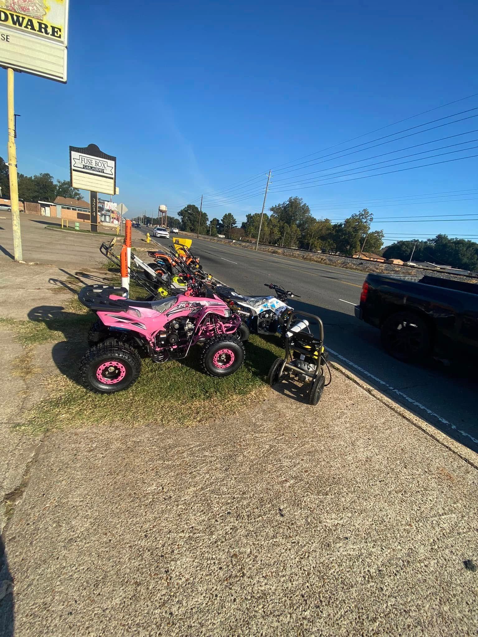 A pink atv is parked on the side of the road.
