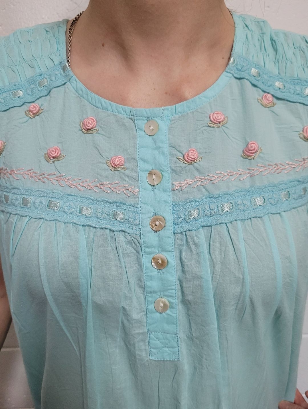 A Woman is Wearing a Blue Shirt With Pink Flowers on It — Shona's Lingerie in Hermit Park, QLD