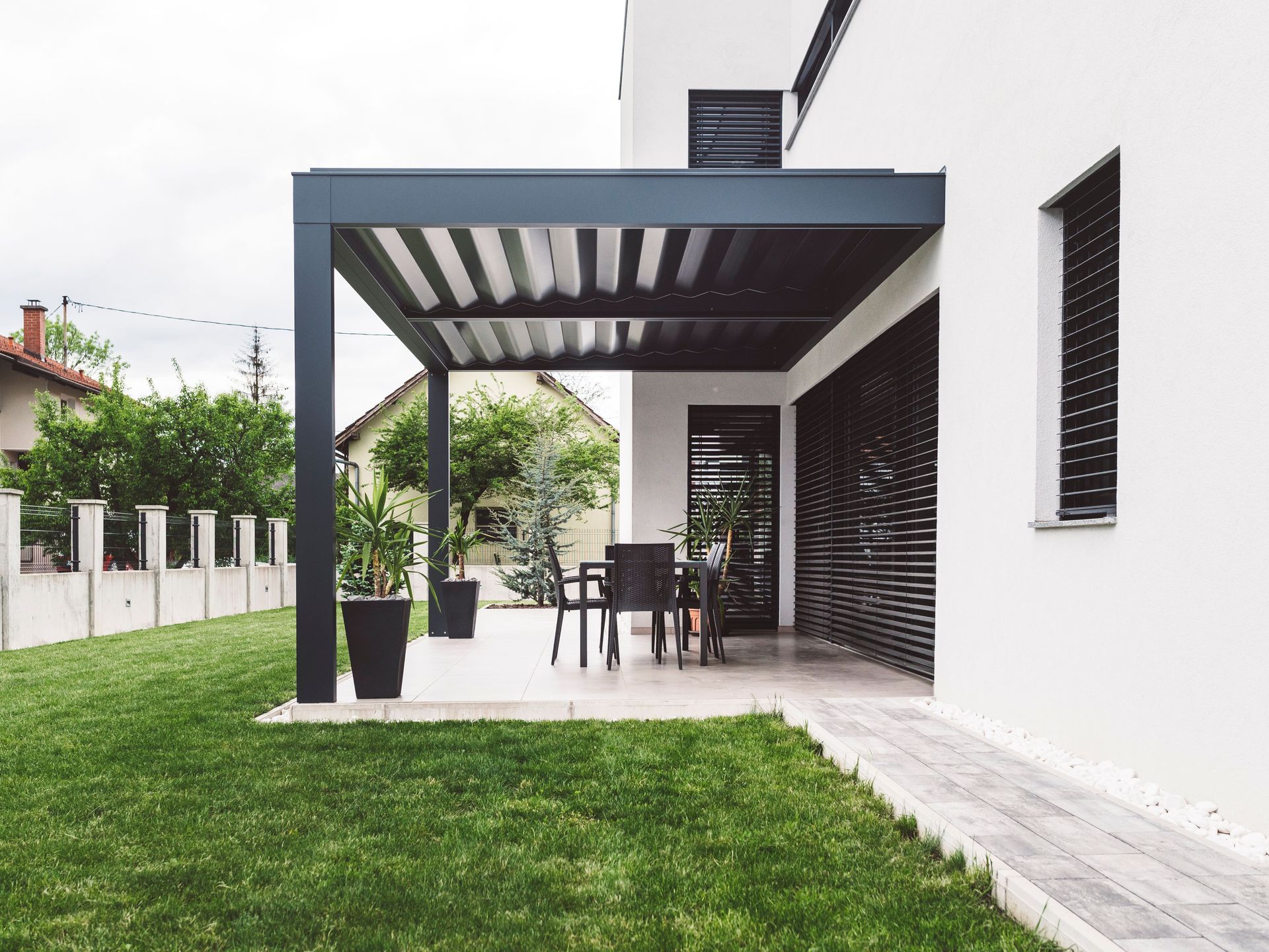 SunPro motorized exterior screen on covered patio – Eastvale
A white house with a pergola in the backyard.