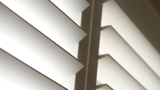 A close up of a white shutter on a window