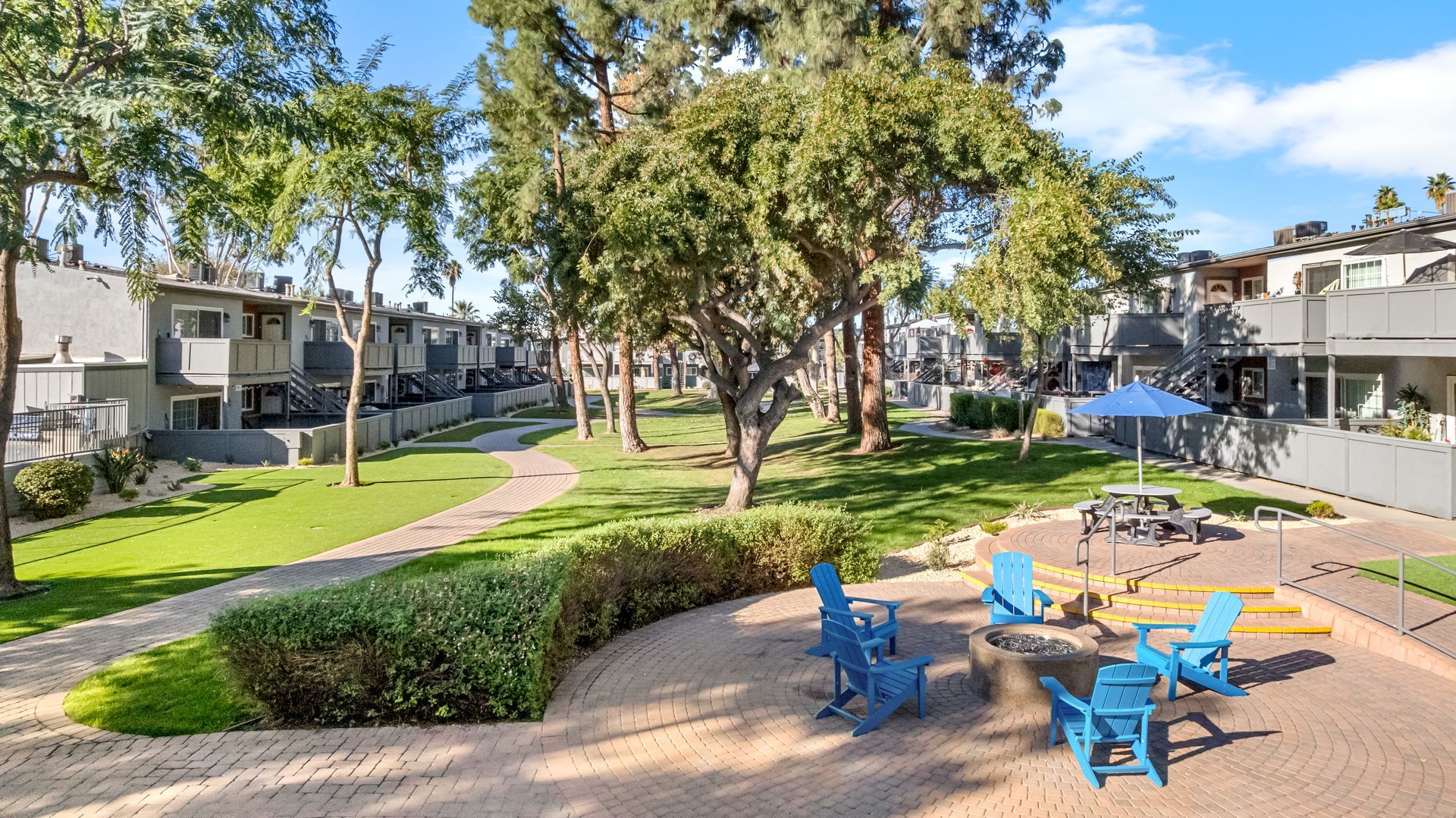 hedges, trees, and fire pit surrounded by chairs