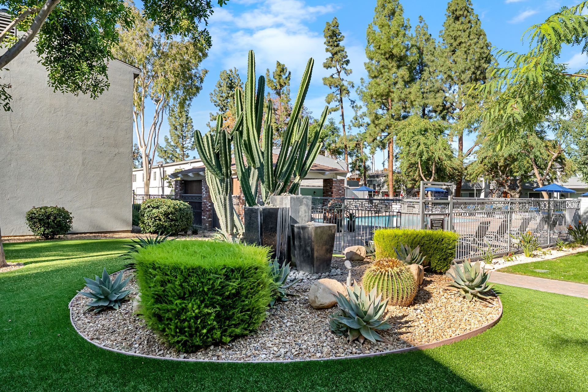 exterior landscaping with hedges, suculents, and a fountain