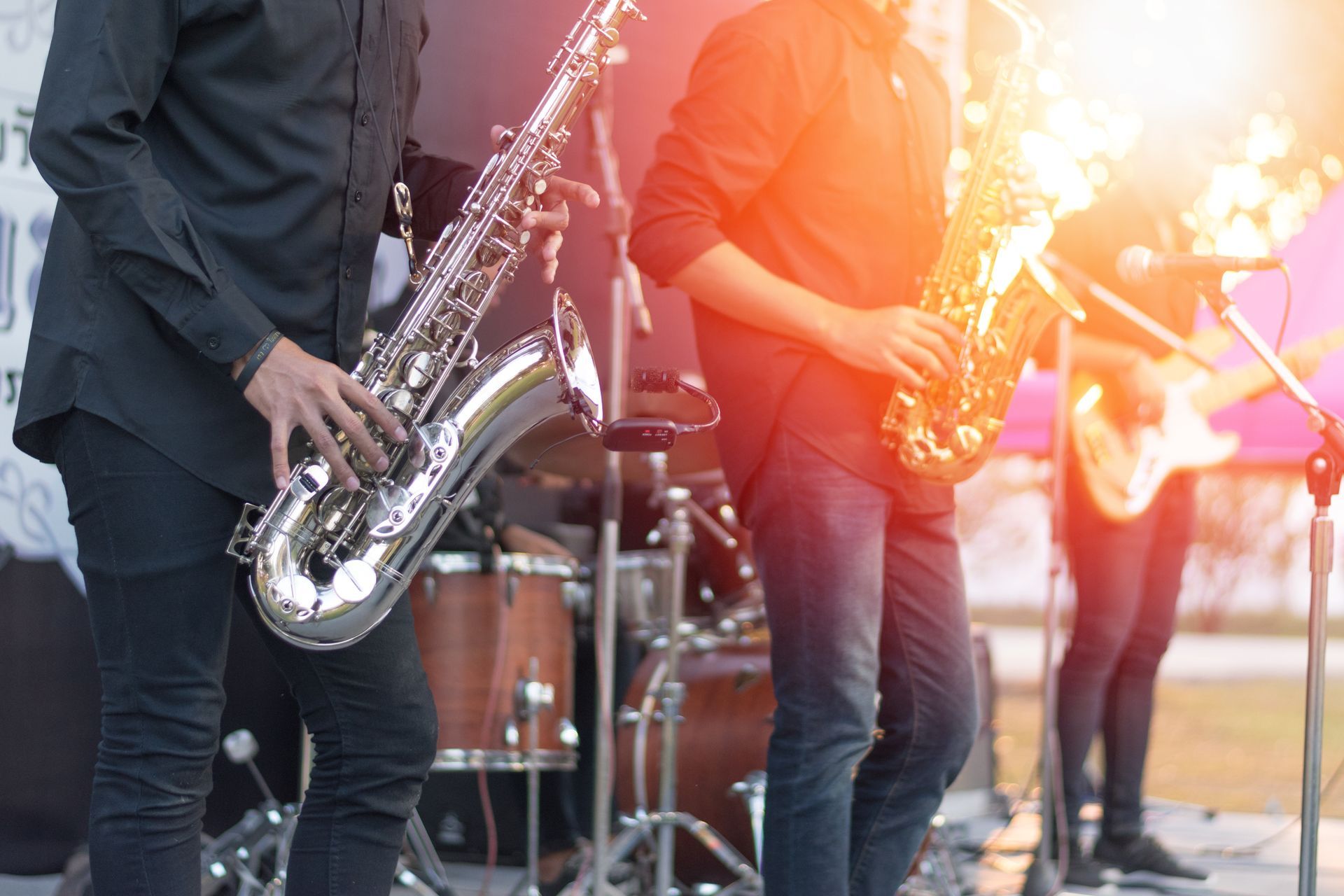 a man is playing a saxophone in a band on a stage .